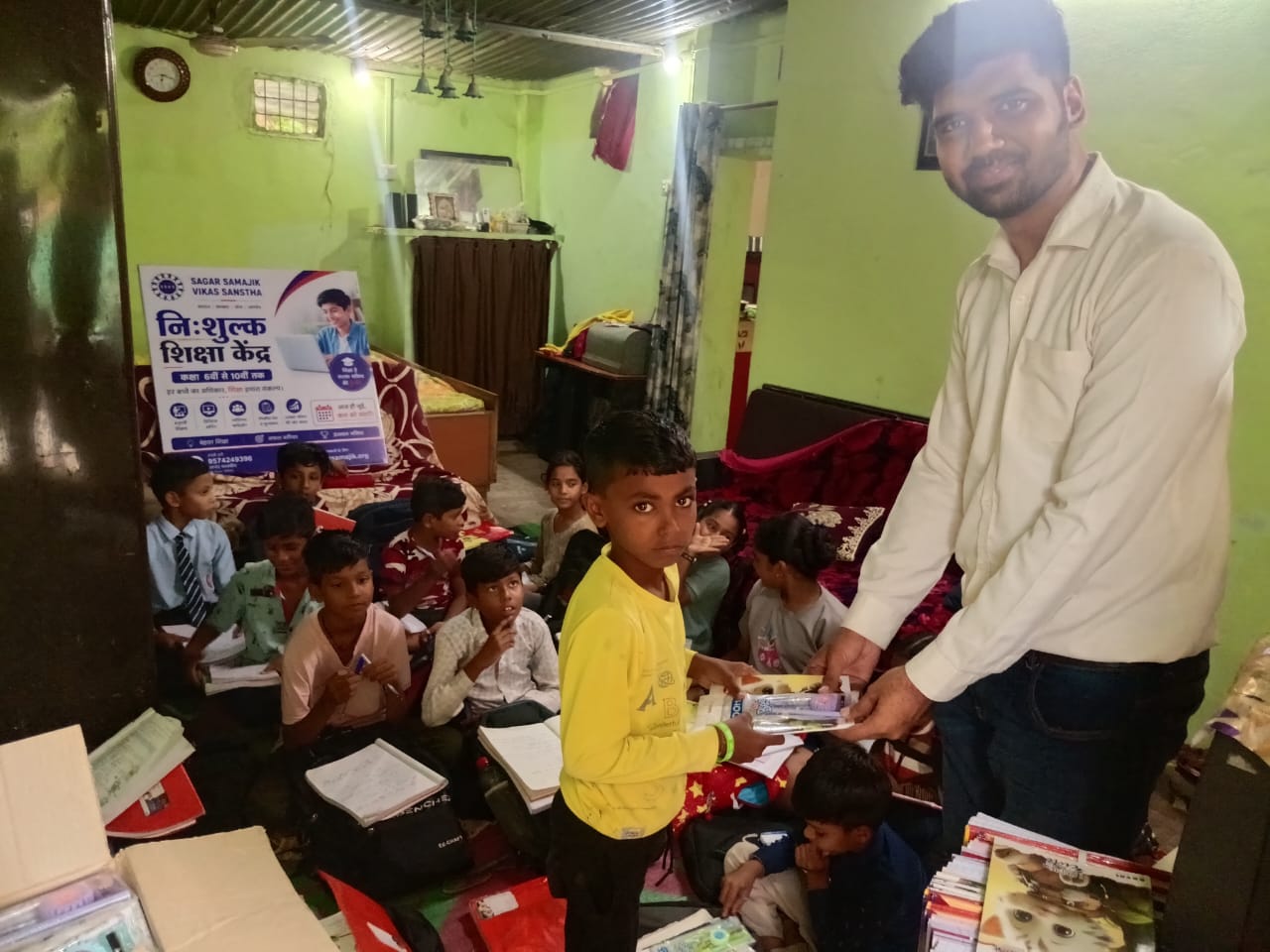 SSVS volunteer distributing stationery to a student at Dilip Nagar centre